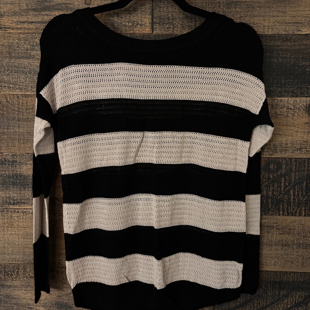 Small beige and black boatneck light weight sweater with button back detail.